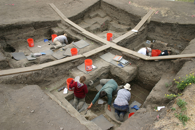 several people in a pit working on an excavation