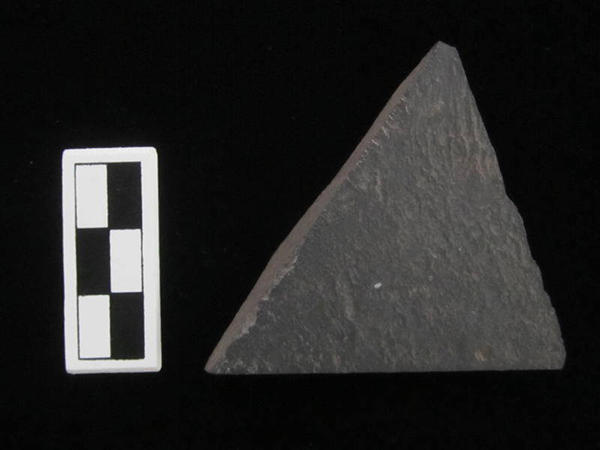 Stone (slate) triangular adze with sawed margins