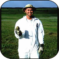Brian in a protective suit smiling on the prairie