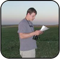 Dave on the prarie at dusk reading a information