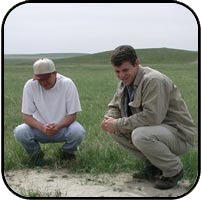 Dave and another researcher inspecting the ground on a prairie