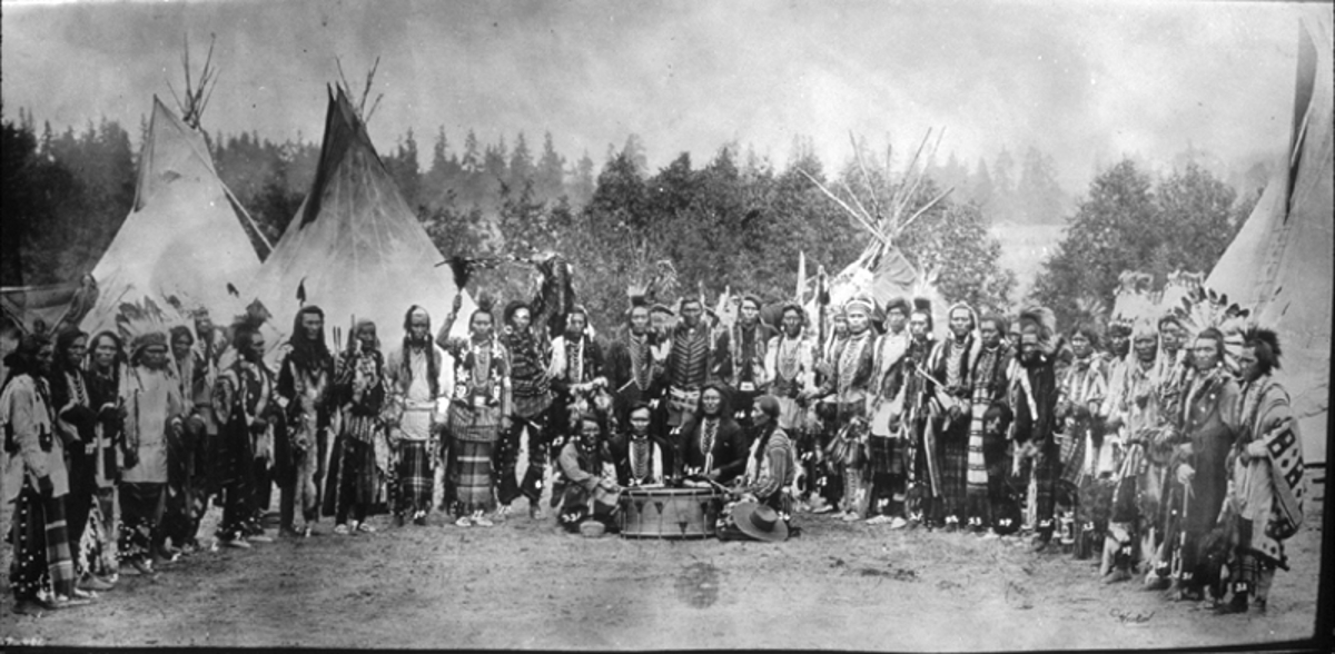 Salish men near tipis year 1903