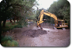backhoe digging in a flooded river